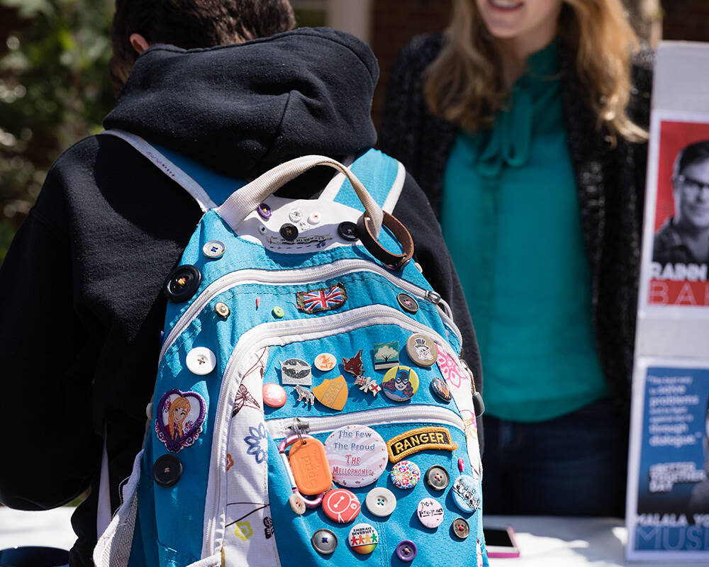 Student with backpack with a lot of buttons and patches